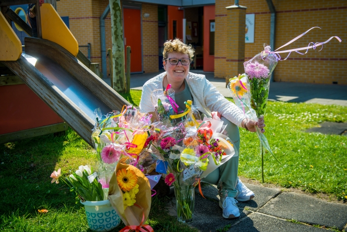 Juf Judith met haar bloemen bij peuterspeelzaal De Ark