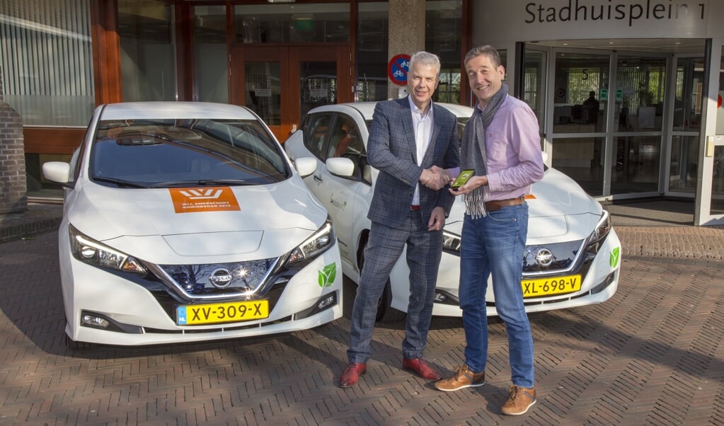 Buurauto directeur Alex van der Woerd 'overhandigt' wethouder Hans Buijtelaar de slutels voor acht nieuwe, duurzame deelauto's
