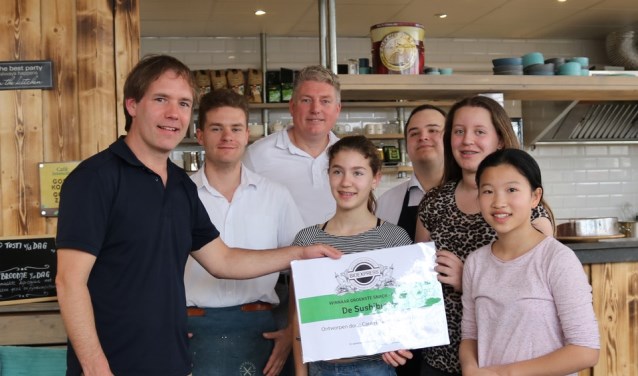 Personeel van de BioExpress reikt de prijs uit aan Team Sushi-burger.
