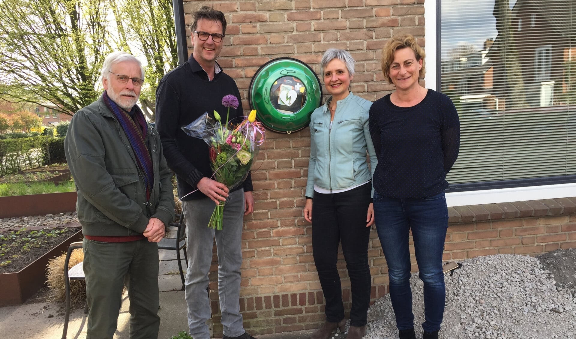 Cisca Pittie en Leonard Baart overhandigen Ton de Kroon en Liesbeth v. Rijnsbergen een boeket als dank voor het realiseren van de AED