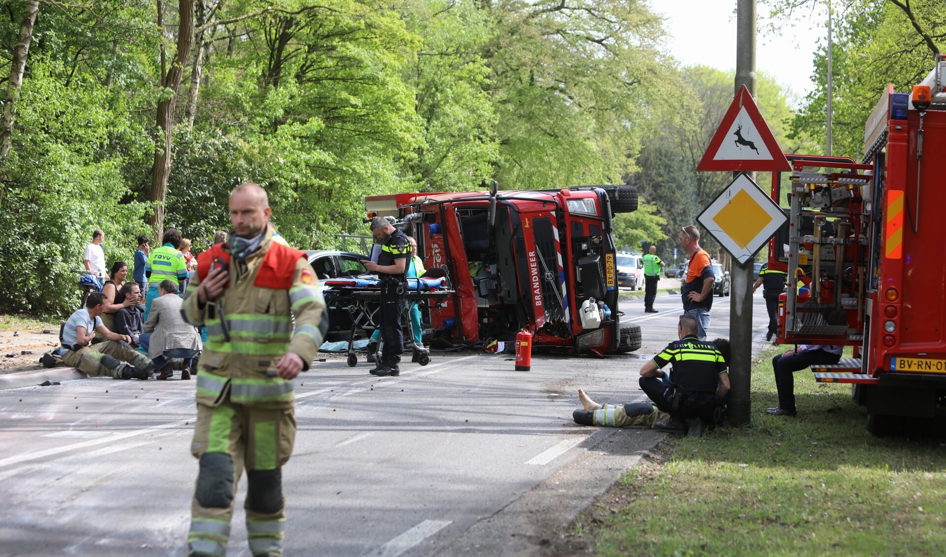 De gecrashte brandweerwagen. Een aantal gewonden zit in de bermen.