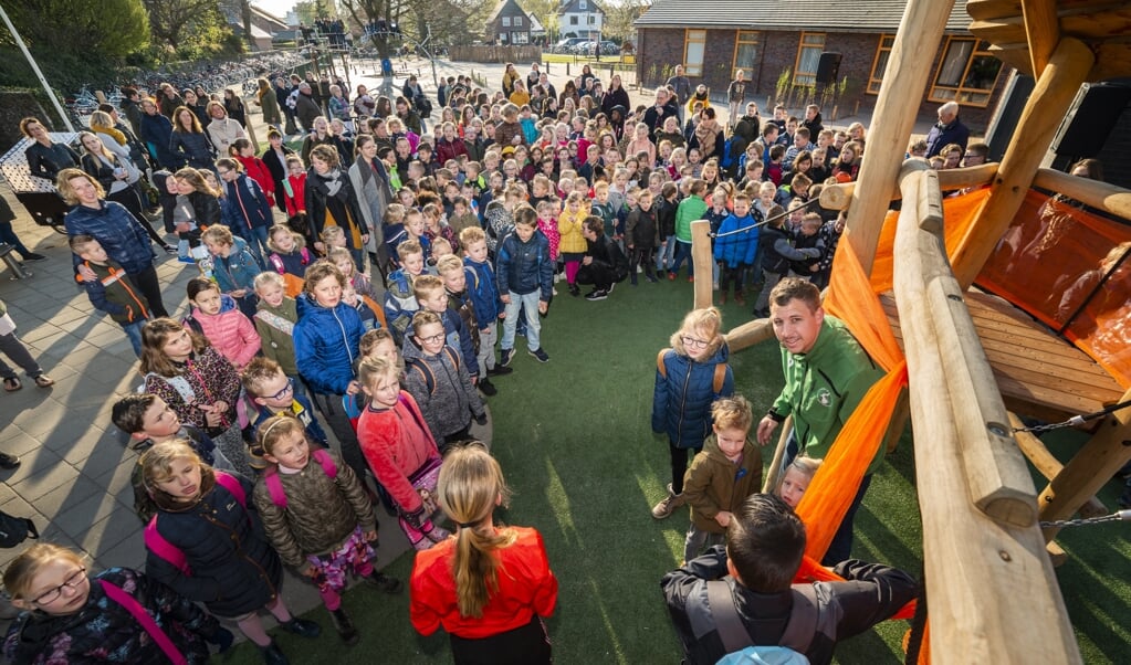 Met het lostrekkken van een grote oranje strik openden leerlingen van De Koningin Wilhelminaschool hun vernieuwde schoolplein.