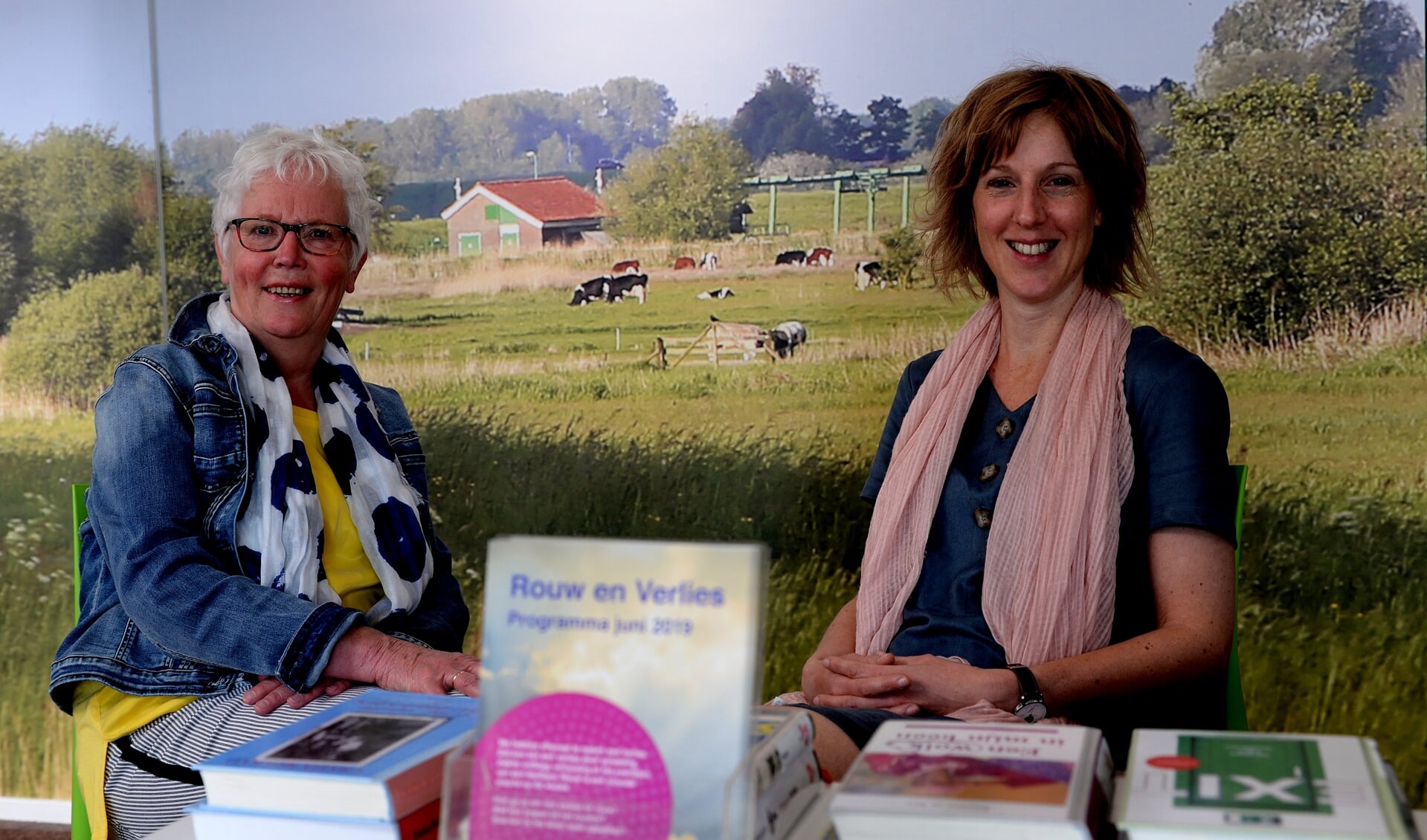 Thea Kloek (links) en Mariëlle Schipperen (rechts) bij de themaboekentafel in de Bibliotheek Nijkerk.