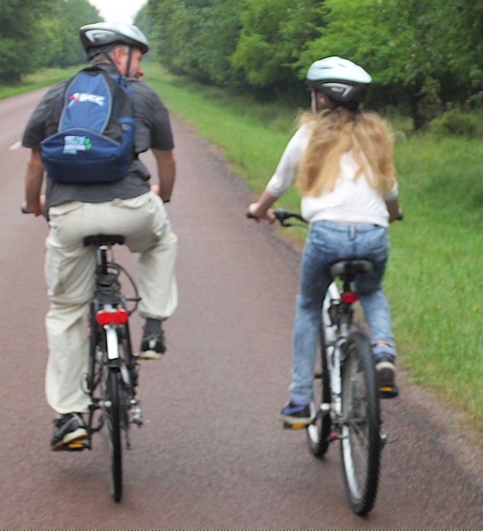 Ouder en kind fietsen samen.
