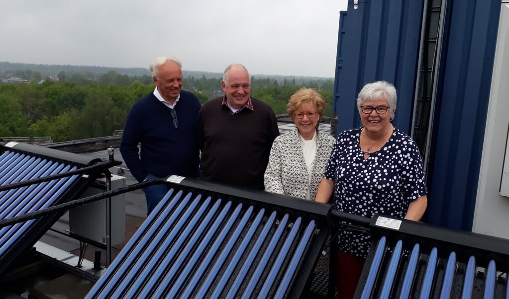De leden van de bewonerscommissie op het dak van Honsbergen waar nu zonnepanelen prijken. Het gebouw aan de Wiardi Beckmanstraat is helemaal opgeknapt en kan weer enkele decennia mee.