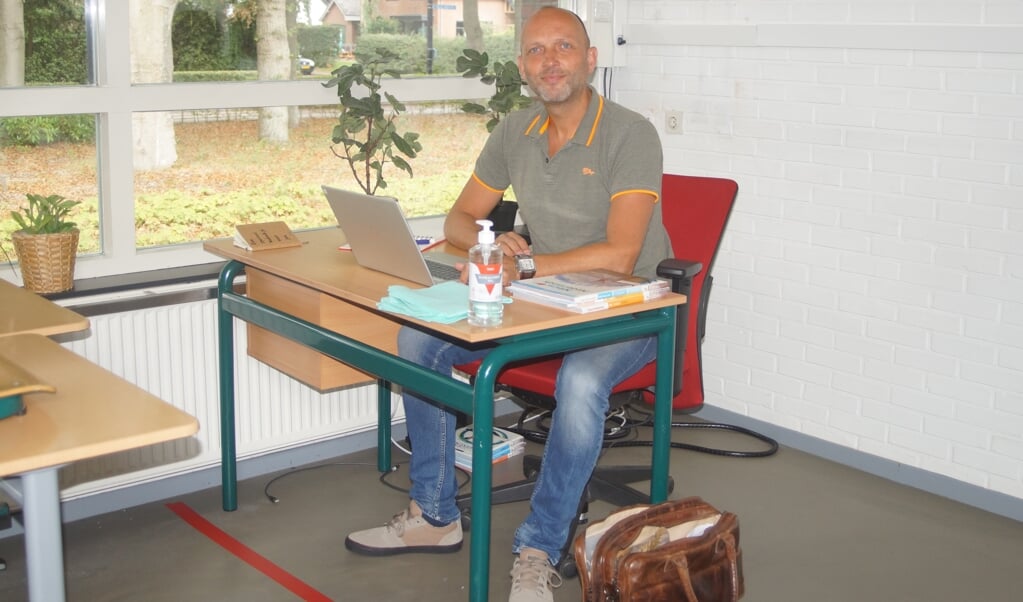 Docent en woordvoerder van Groevenbeek Eward Cozijnsen is maandag klaar voor het nieuwe schooljaar. Op het bureau staat handalcohol met schoonmaakdoekjes. Op de grond ligt een rode lijn om afstand te waarborgen.