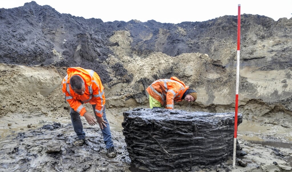 Archeologen Ton Wolf (links) en Michiel Meurs bekijken een eeuwenoude waterput die bij het archeologisch werk in Voorthuizen werd aangetroffen.
