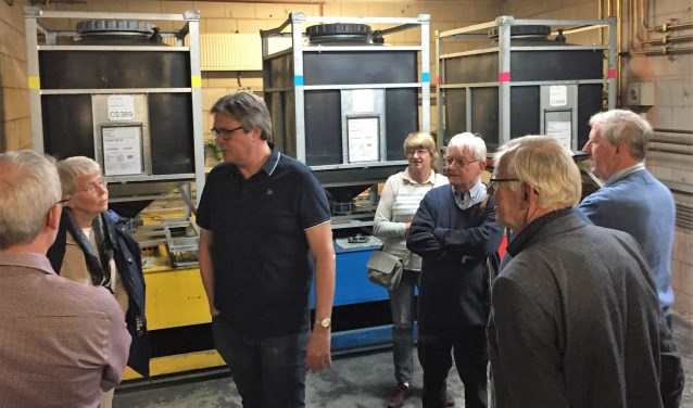 Daan Bleuel (BDU) geeft uitleg over het drukproces, met op de achtergrond 'inktcartridges' van 1000 liter per kleur.