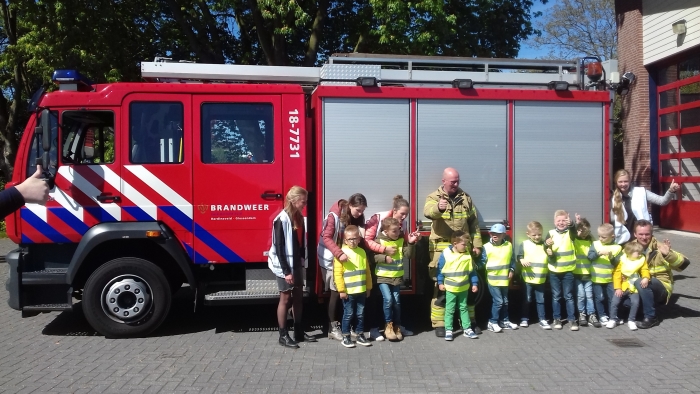 De kinderen met jufs bij de brandweerwagen