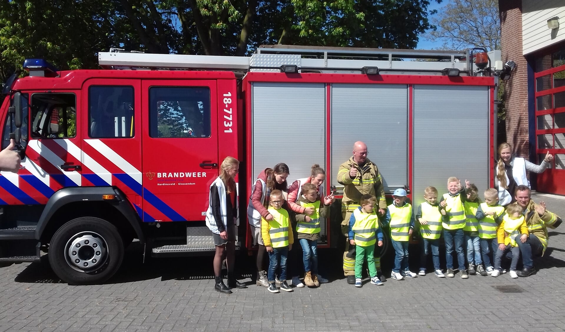 De kinderen met jufs bij de brandweerwagen