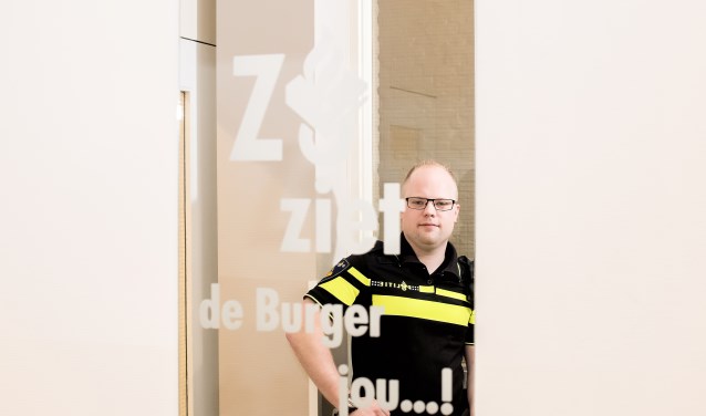 Wijkagent Gerben Algra kijkt in de spiegel