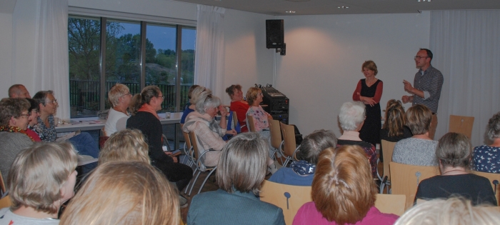 Christa Anbeek (links) en Christiaan Rhodius (rechts) voor een volle zaal in hospice Bardo.