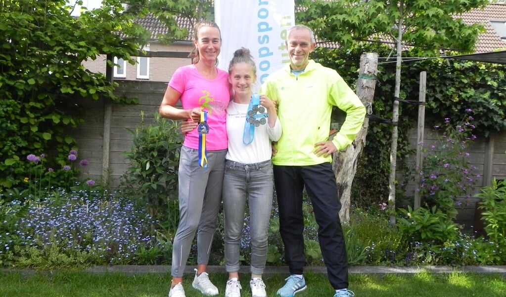 Lisette, Noëlle en Fred tonen trots de behaalde medailles. Op het T-shirt van Noelle staat de door haar zelf gekozen tekst: 