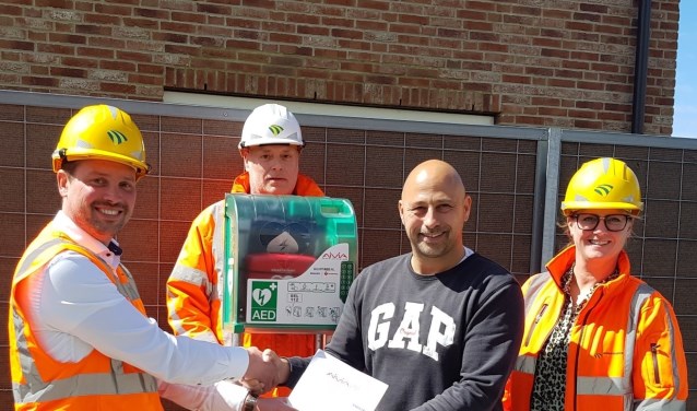 v.l.n.r. Bedrijfsleider Jeroen Turenhout, Gebiedsassistent Fred Heisterkamp en Omgevingsmanager Leontien Benders overhandigen namens DURA Vermeer de 1e Buurt AED van Tudorpark aan initiatiefnemer Harry Schuit.