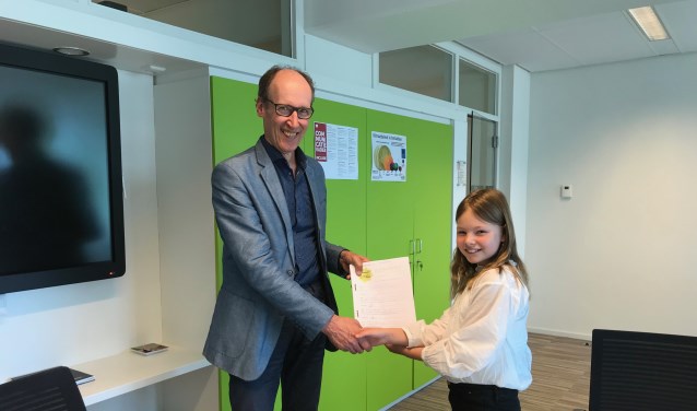 Wethouder Hoefsloot krijgt de handtekeningen uit handen van Sterre Overbeeke.