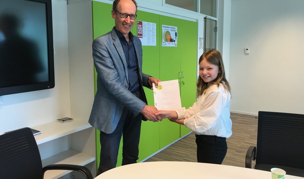 Wethouder Hoefsloot krijgt de handtekeningen uit handen van Sterre Overbeeke.