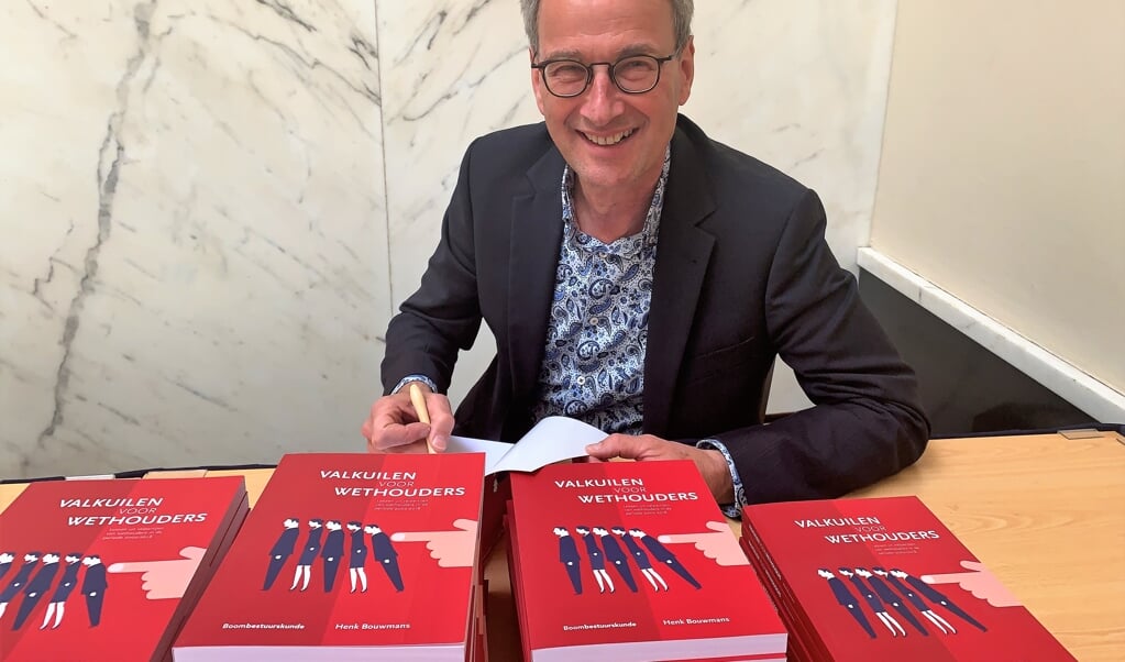 Henk Bouwmans met zijn boek Valkuilen voor wethouders. 