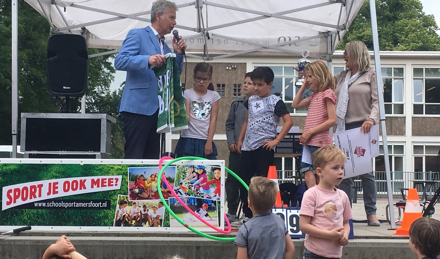 Wethouder Buijtelaar reikt de prijs uit aan enkele leerlingen van de Joost van den Vondelschool