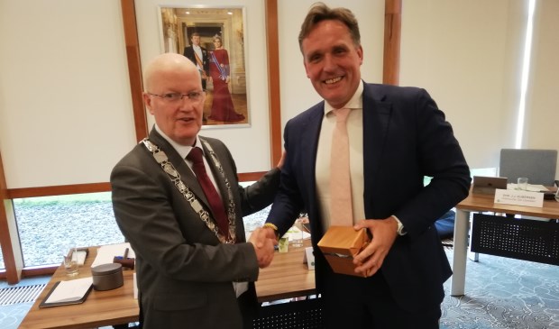 Burgemeester overhandigt Eijbersen een horloge op zonneenergie