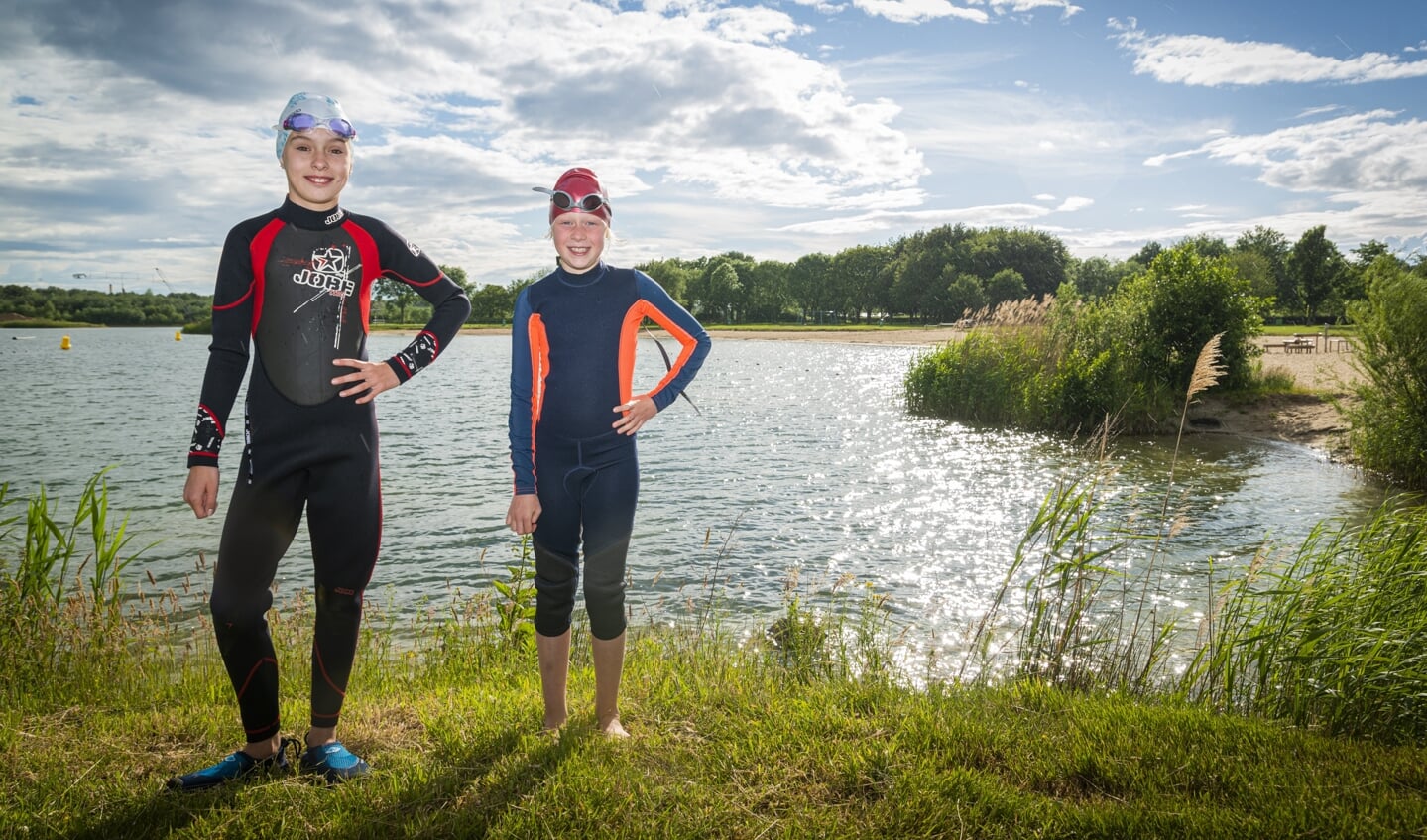 Zwenster Maud (links) en Lili bereiden zich in de Zeumerse Plas voor op hun  zwemtocht met Maarten van der Weijden. 