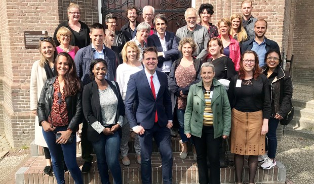 Deelnemers aan de Werkconferentie Armoedebeleid bij de toren van de Urbanuskerk dioe ze na afloop mochten beklimmen.