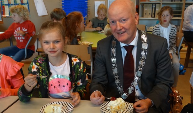 Beide burgemeesters samen aan de taart