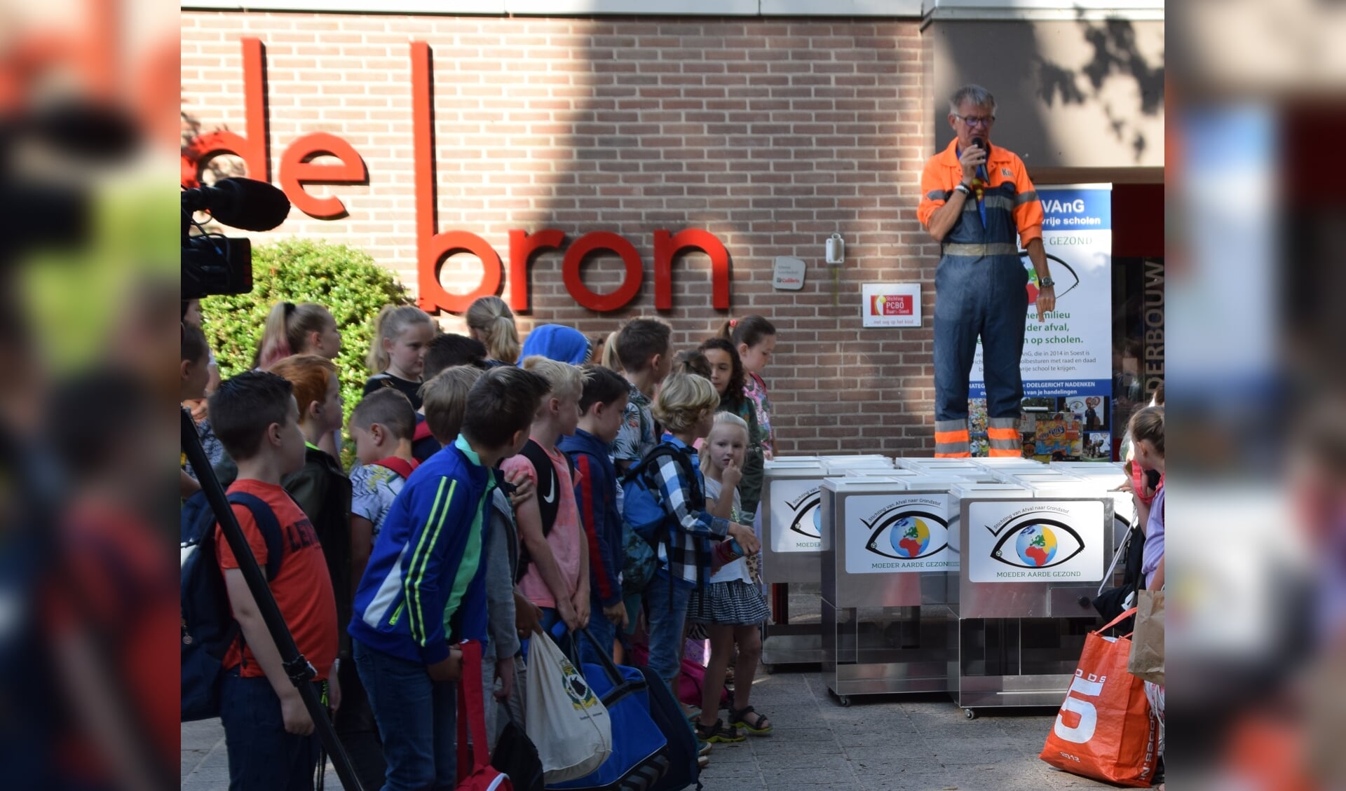 Koos de Vuilnisman vertelt op het schoolplein over de noodzaak van het scheiden van afval