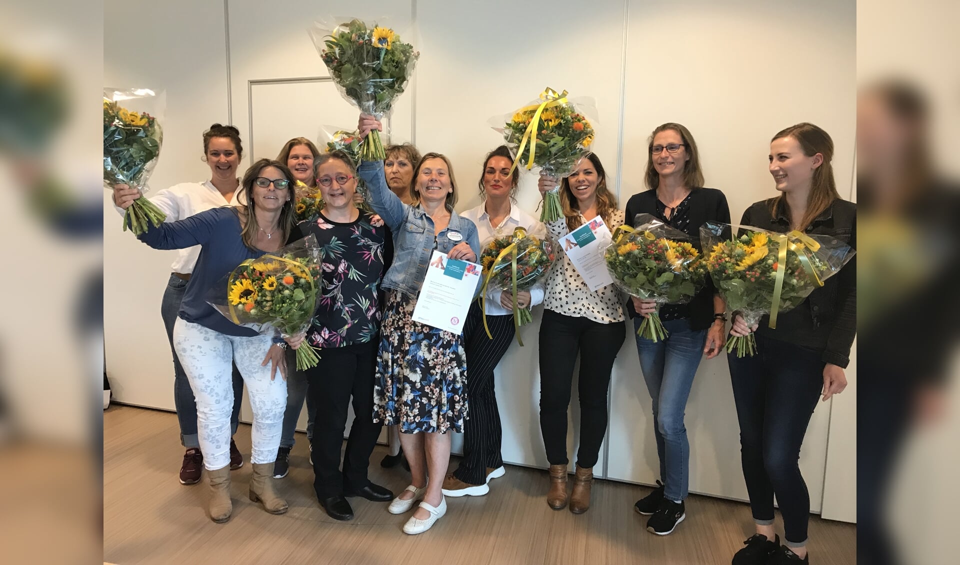 De groep kwaliteitsverpleegkundigen van QuaRijn viert het behalen van hun certificaten.