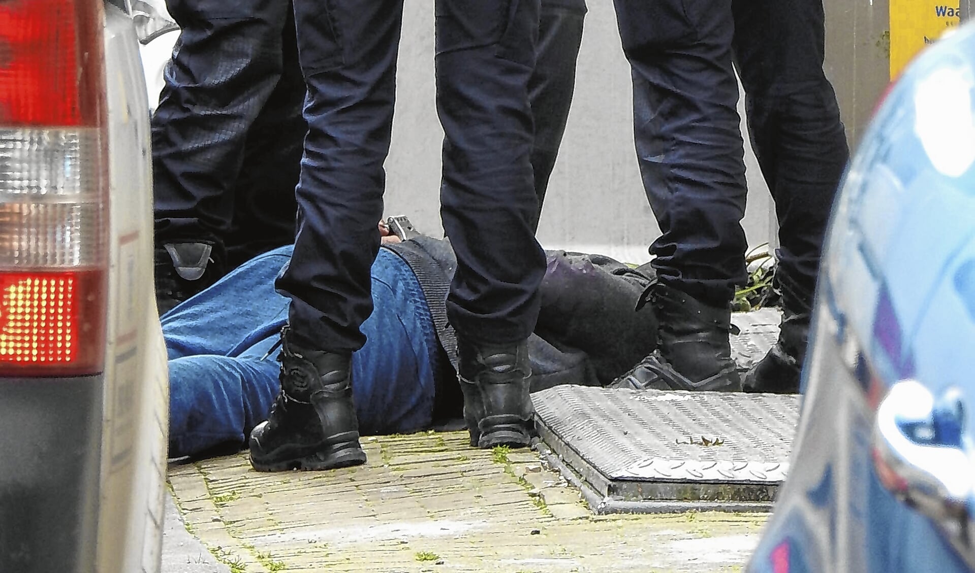 Een Amsterdamse arrestant ligt op de grond. Hoes wil niet dat die naar Schiphol wordt gebracht.  