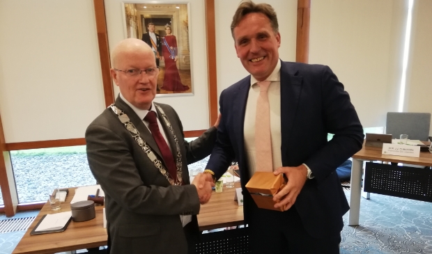 <p>Burgemeester overhandigt Eijbersen bij zijn afscheid in 2019 een horloge op zonne-energie</p>