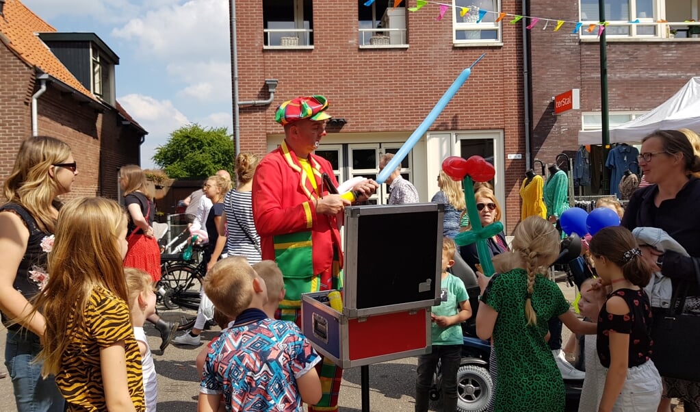 Een clown vermaakt kinderen op de feestmarkt.
