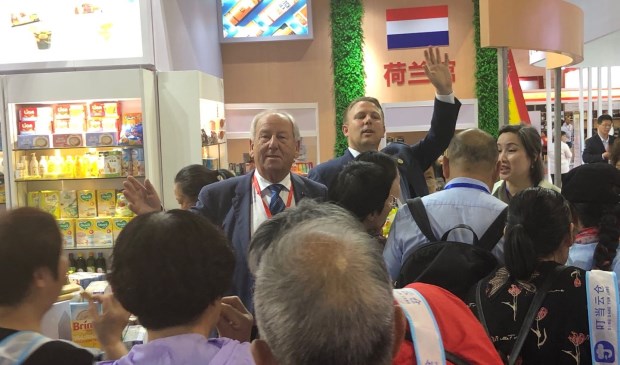 Gerard van den Tweel (midden): ,,De Chinezen blijken gek te zijn op de typisch Nederlandse producten die wij uitdeelden.'' Rechts achter hem collega Cees van der Poel uit Dordrecht.