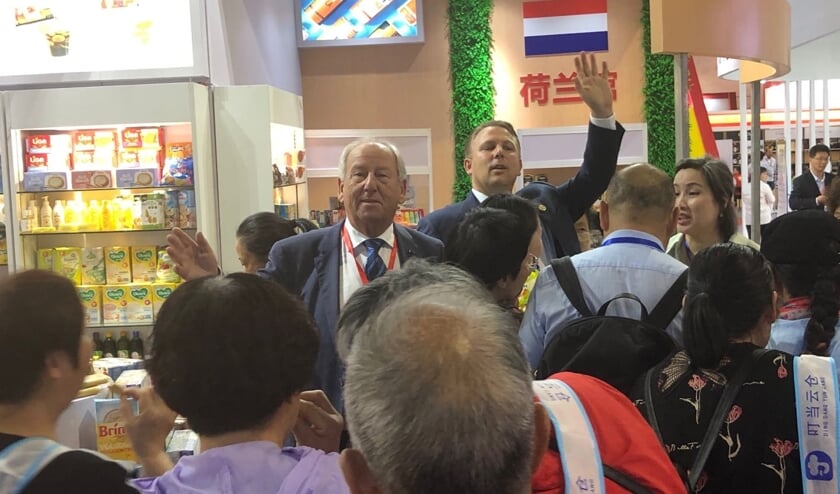 Gerard van den Tweel (midden): ,,De Chinezen blijken gek te zijn op de typisch Nederlandse producten die wij uitdeelden.'' Rechts achter hem collega Cees van der Poel uit Dordrecht.