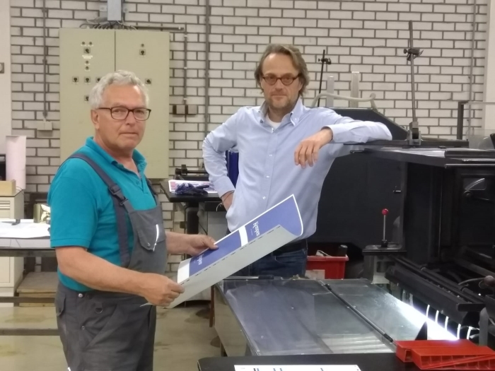 Kor met directeur Albert Tuijtel bij een boekdrukpers