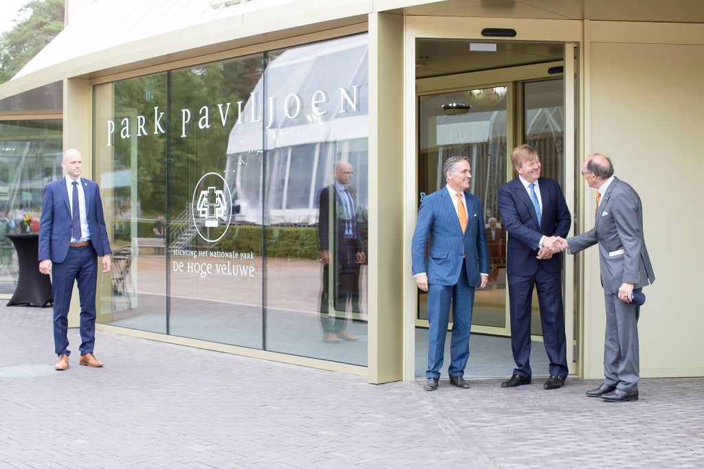 Koning Willem-Alexander wordt begroet door voorzitter Fred de Graaf van de raad van toezicht van Nationaal Park De Hoge Veluwe. Links van de koning parkdirecteur Seger baron van Voorst tot Voorst.