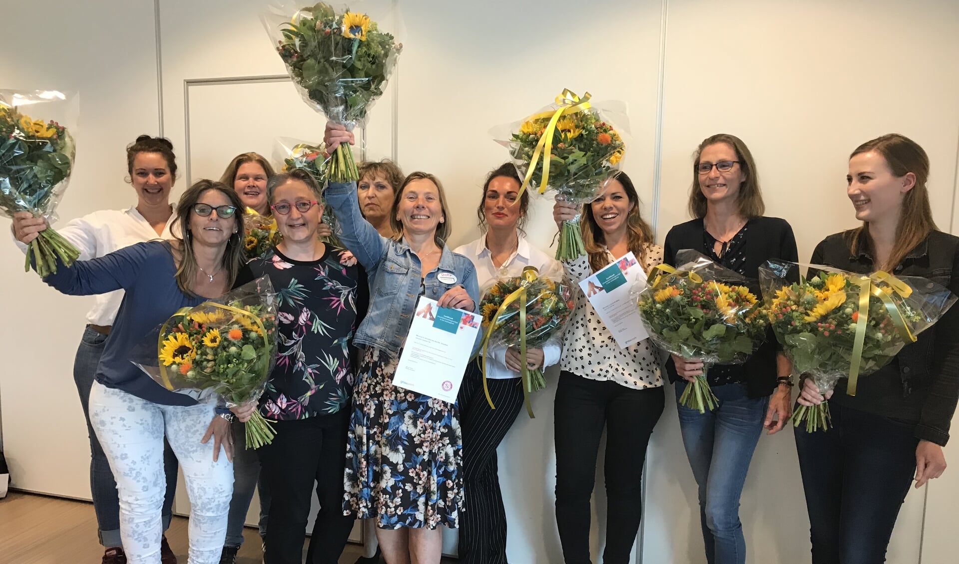 De groep kwaliteitsverpleegkundigen van QuaRijn viert het behalen van hun certificaten.