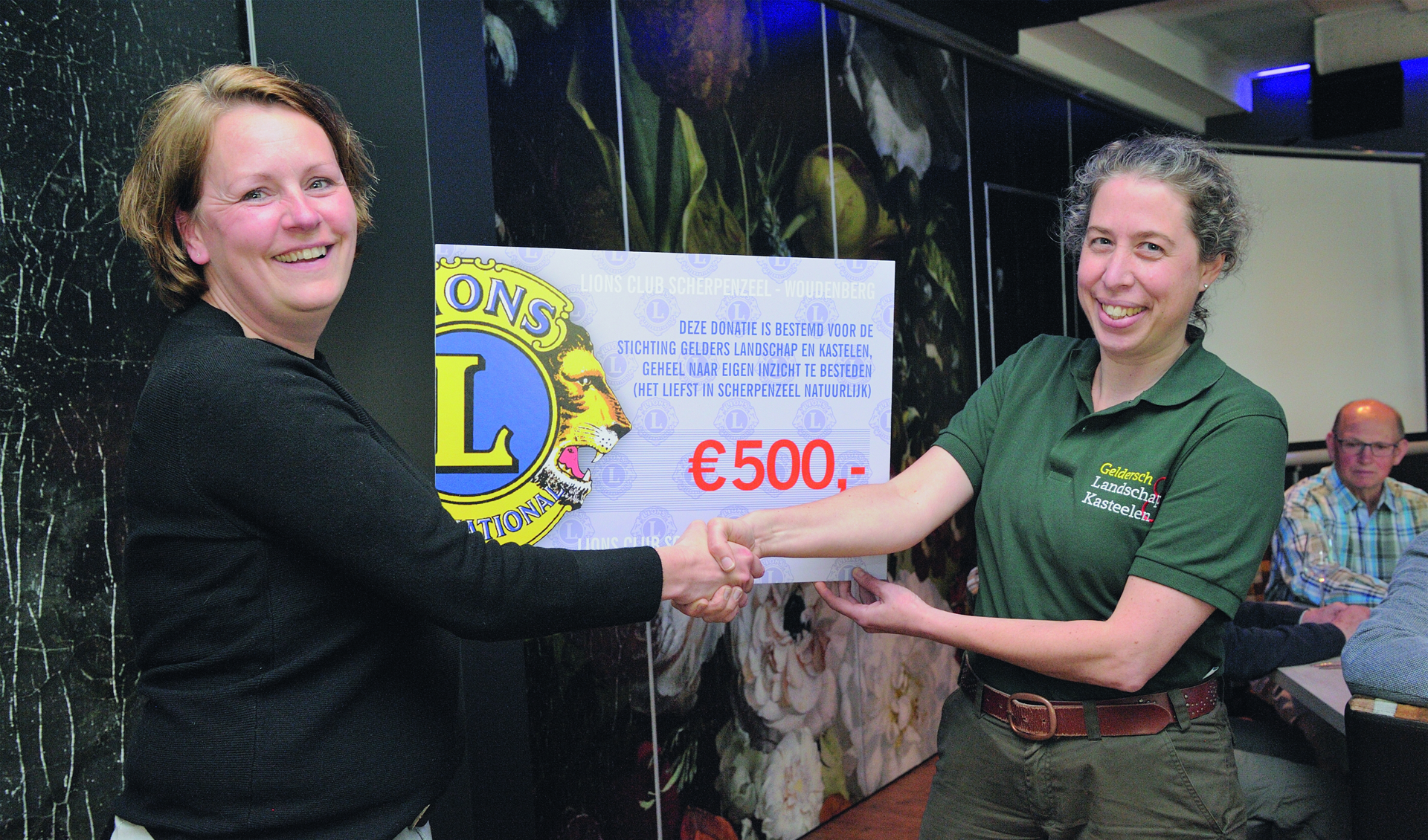 President Lonneke van Dijk van de Lions overhandigt de cheque aan Anja Koning