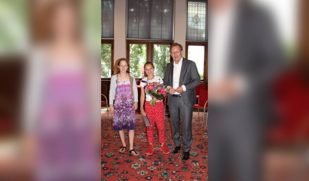 Kinderburgemeester Anna (l) en burgemeester Koos Janssen feliciteren Melief als nieuwe aankomende kinderburgemeester. FOTO: Gemeente Zeist 