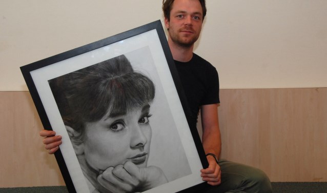 Martijn Versteeg met een portret van Audrey Hepburn.