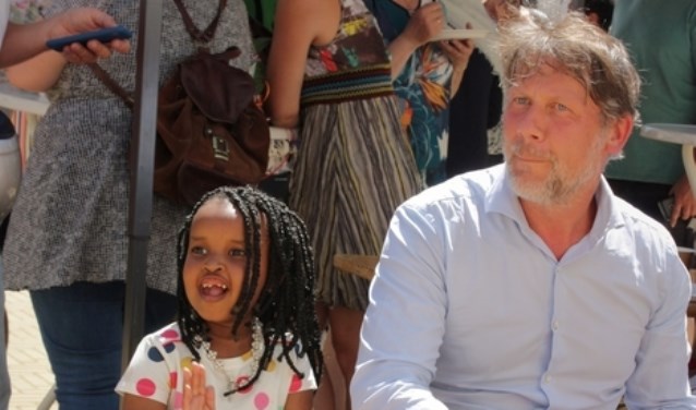 Dit meisje speelt vrolijk djembee met wethouder Ro van Doesburg.