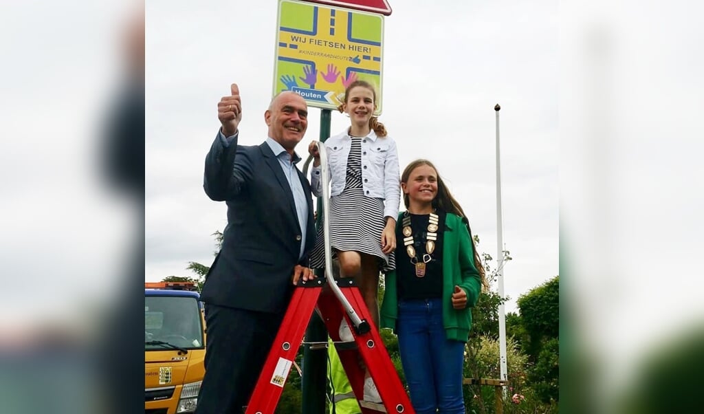 Wethouder Kees van Dalen, ontwerpster Daniëlle van Kuijk en kinderburgemeester Sarah de Kruijff onthullen trots het speciale verkeersbord.