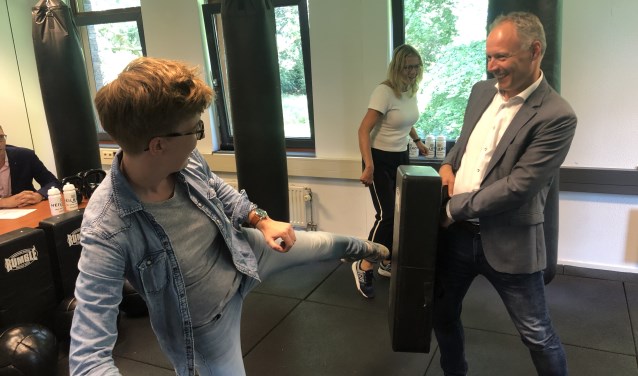 Buurtsportcoach Sandra van Ravenhorst leert Wethouder Patrick Kiel de basisbeginselen van een bokszaktraining.
