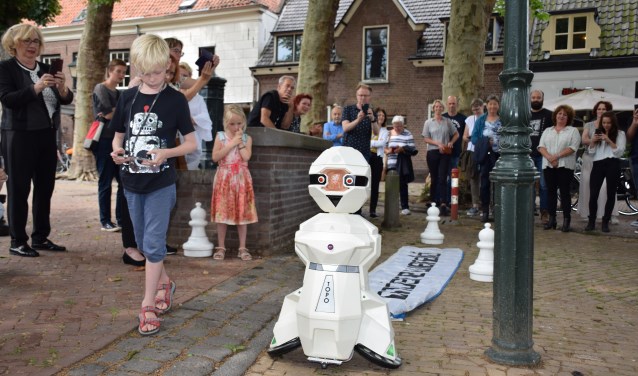 Kleinzoon Lars zet robot Topo aan het werk