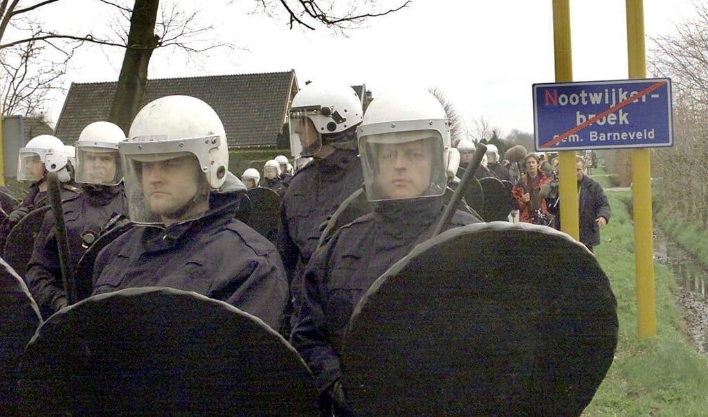 Kootwijkerbroek, 9 april 2001. ME-ers staan klaar om door een blokkade heen te breken, wanneer boze boeren, medestanders en jongeren willen proberen ruimingen bij veehouderijen tegen te gaan. Het illustreert het verzet in het dorp, gevoed door de twijfel over de vermeende MKZ-uitbraak.