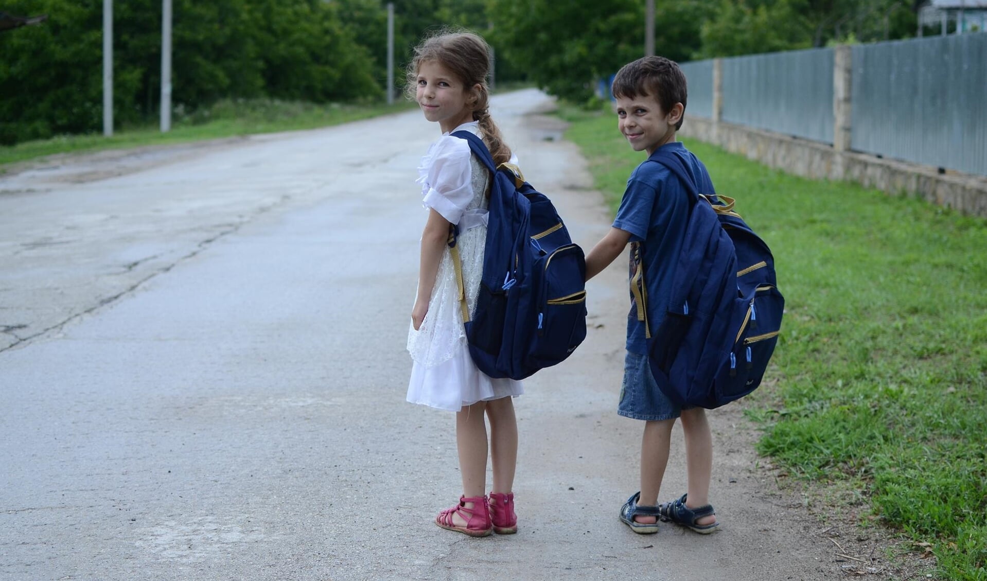 Oost-Europese kinderen op weg naar school met goed gevulde rugzak schoolspullen