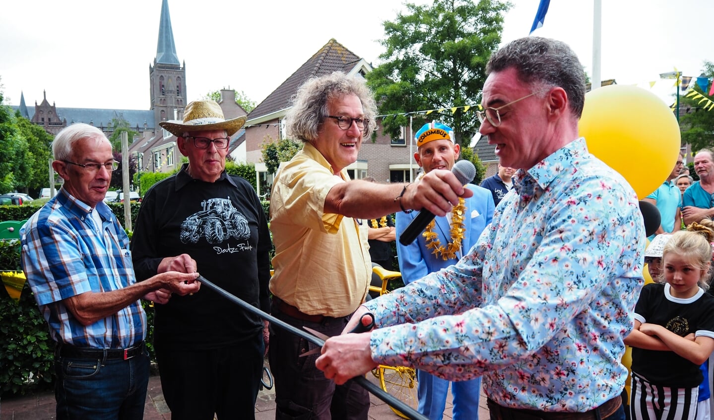 Oudsponsoren houden een fietsband vast die burgemeester Gilbert Isabella mag doorknippen. Willy Kruijssen (in het geel) verzon vijftig jaar geleden de Tour de Schalkwijk.