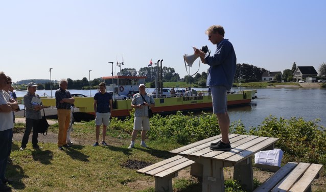 Stadsdichter van Wijk bij Duurstede André van Zwieten leest het eerste couplet voor bij de picknickbank op de veerstoep.
