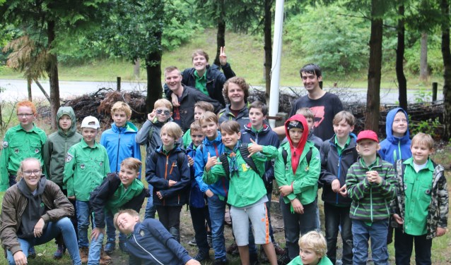 Een enthousiaste groep Jongenswelpen met leiding voor hun vertrek naar hun zomerkamp in Breda.
