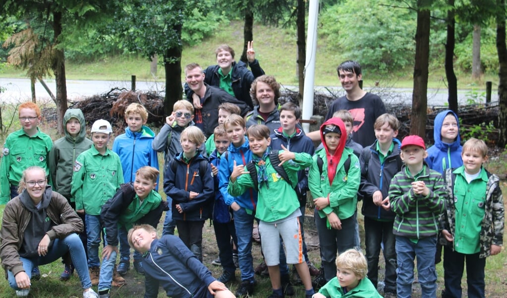 Een enthousiaste groep Jongenswelpen met leiding voor hun vertrek naar hun zomerkamp in Breda.