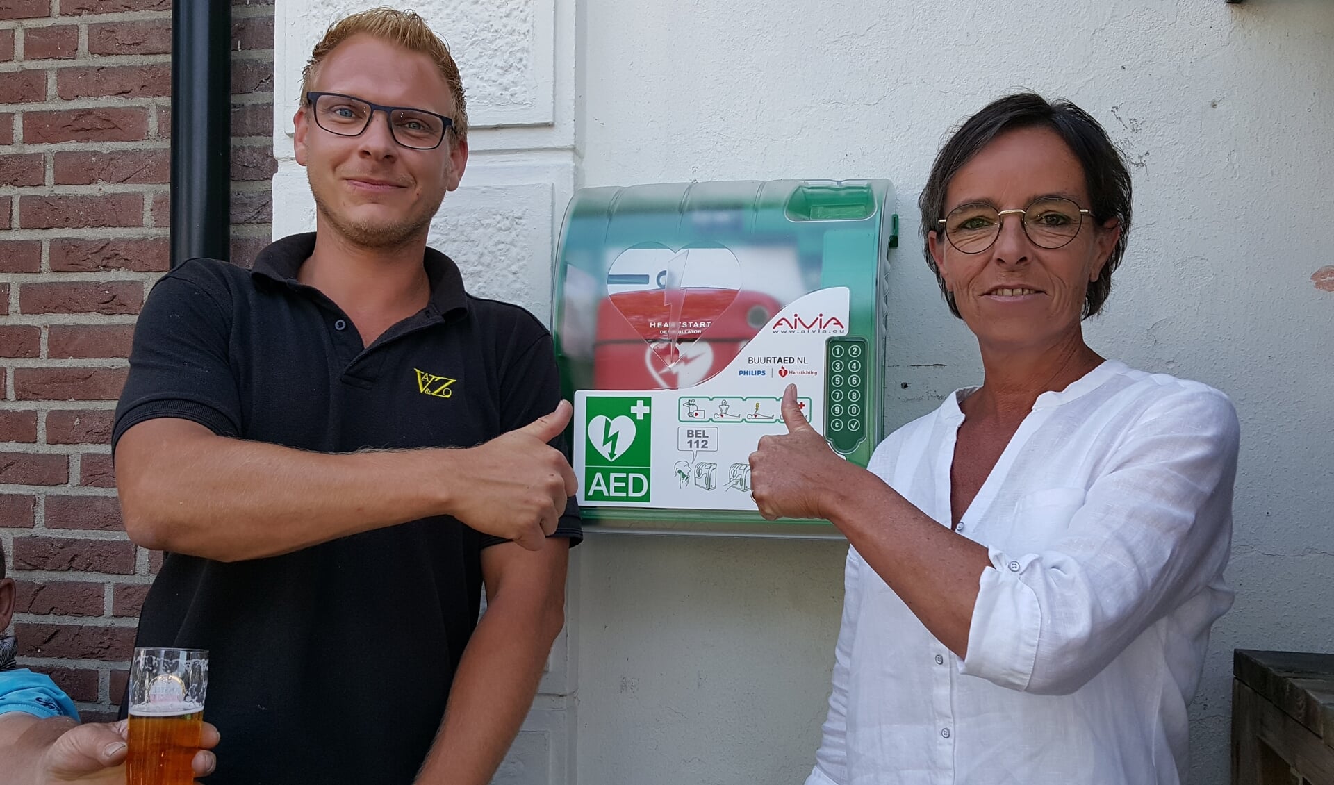 Installateur Jeroen Jensma en Tineke Baan bij de gloednieuwe AED bij d'Oude Enghe.